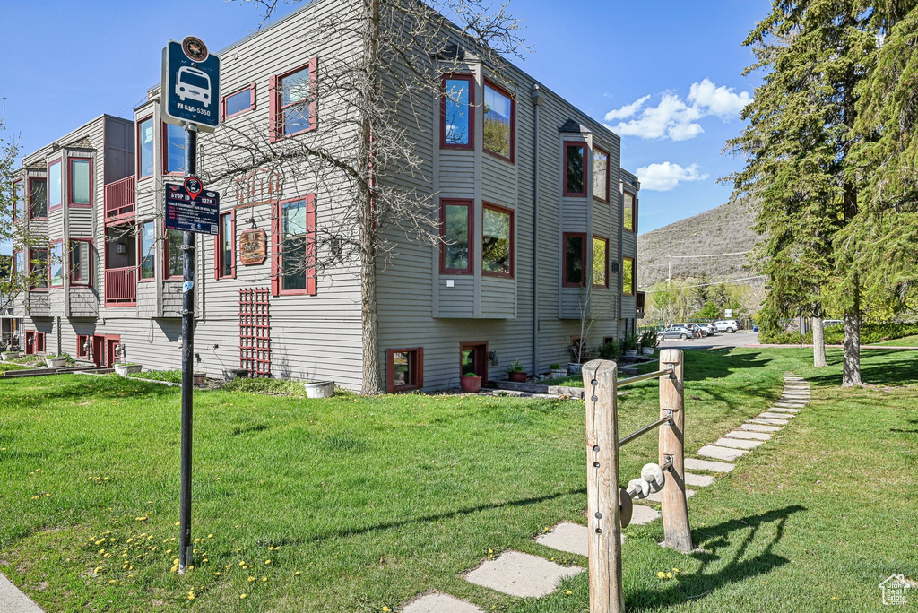 View of side of property with a lawn