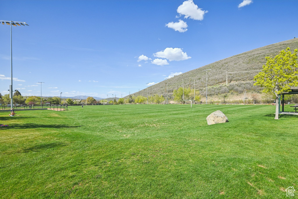 View of property's community with a mountain view and a lawn