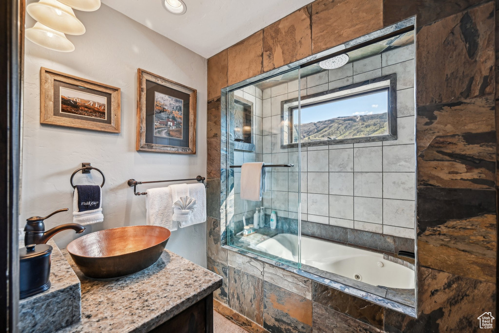 Full bath featuring a tile shower, a whirlpool tub, and vanity