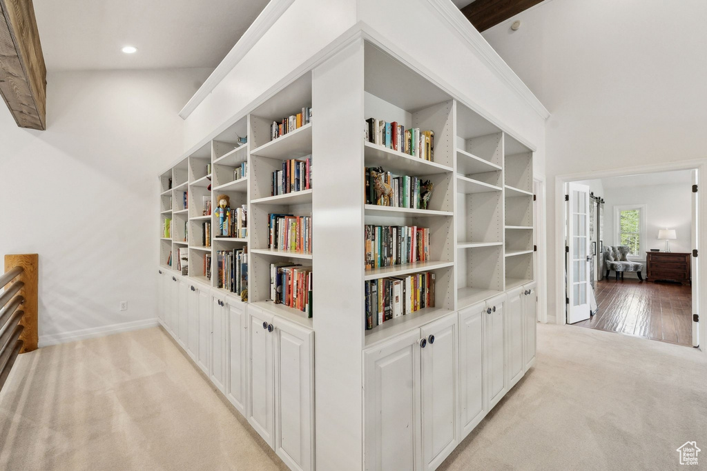 Hallway with light colored carpet, baseboards, recessed lighting, french doors, and built in shelves
