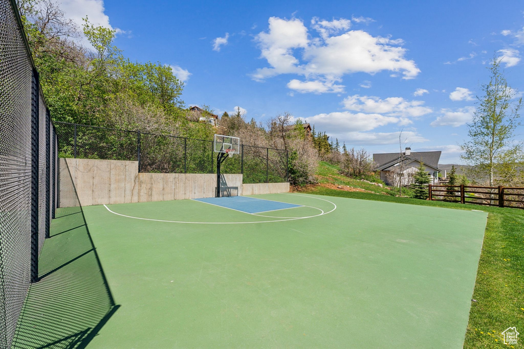 View of sport court featuring basketball court and fence