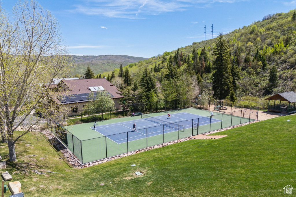 View of tennis court featuring a mountain view and a gazebo