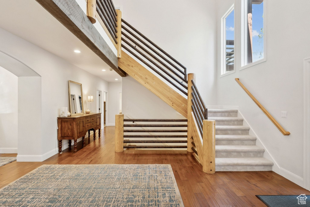 Stairs featuring wood finished floors, recessed lighting, and baseboards