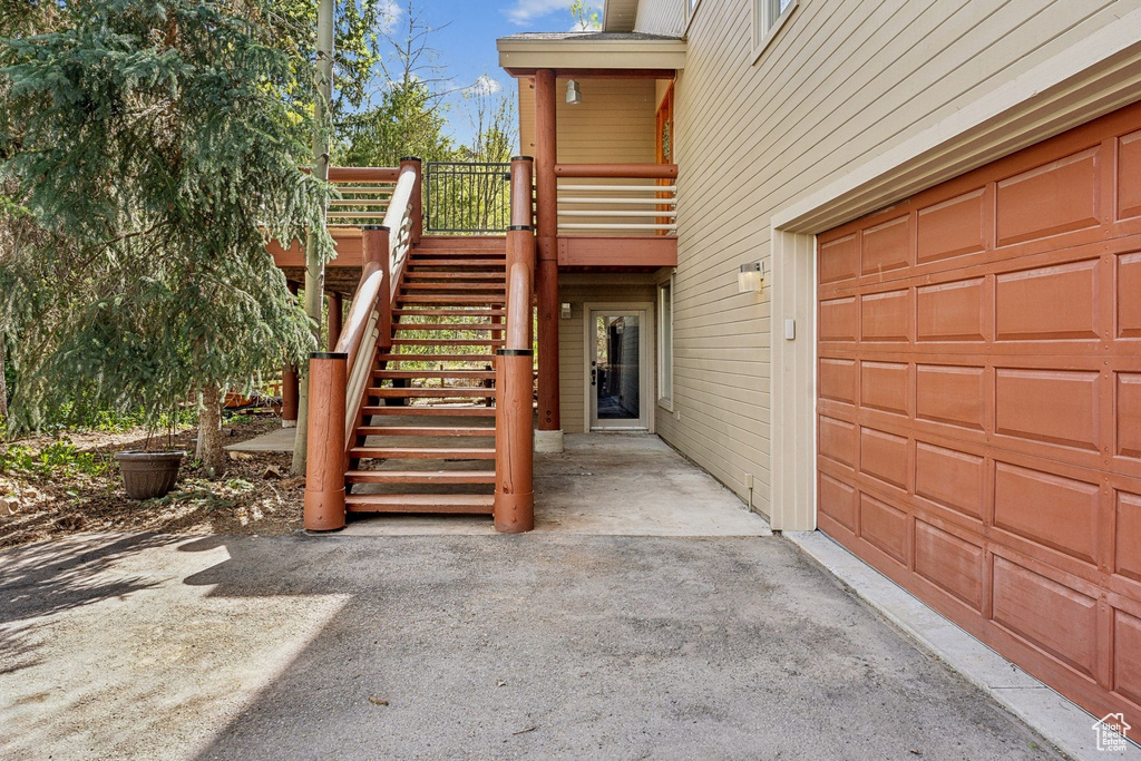 Entrance to property featuring a garage and a deck