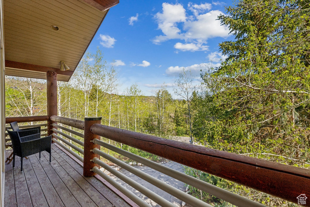 Wooden terrace featuring a wooded view