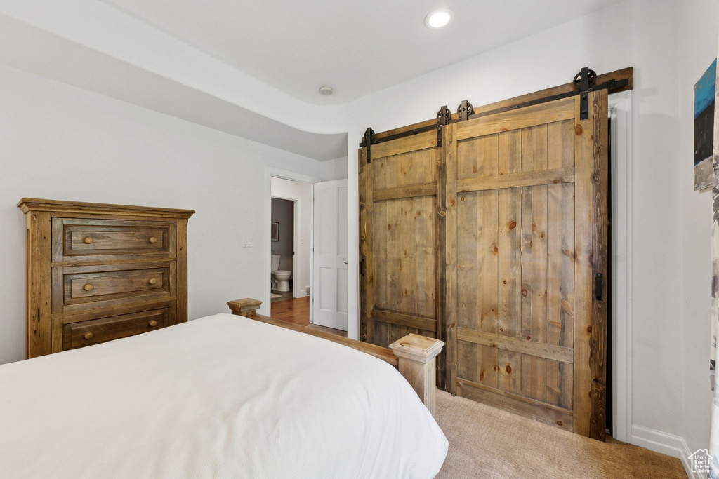 Bedroom with a barn door and recessed lighting