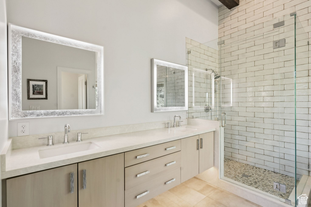 Bathroom with a stall shower, double vanity, and tile patterned flooring