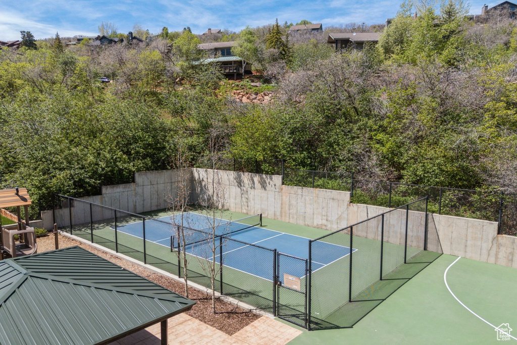 View of tennis court featuring fence and a gate