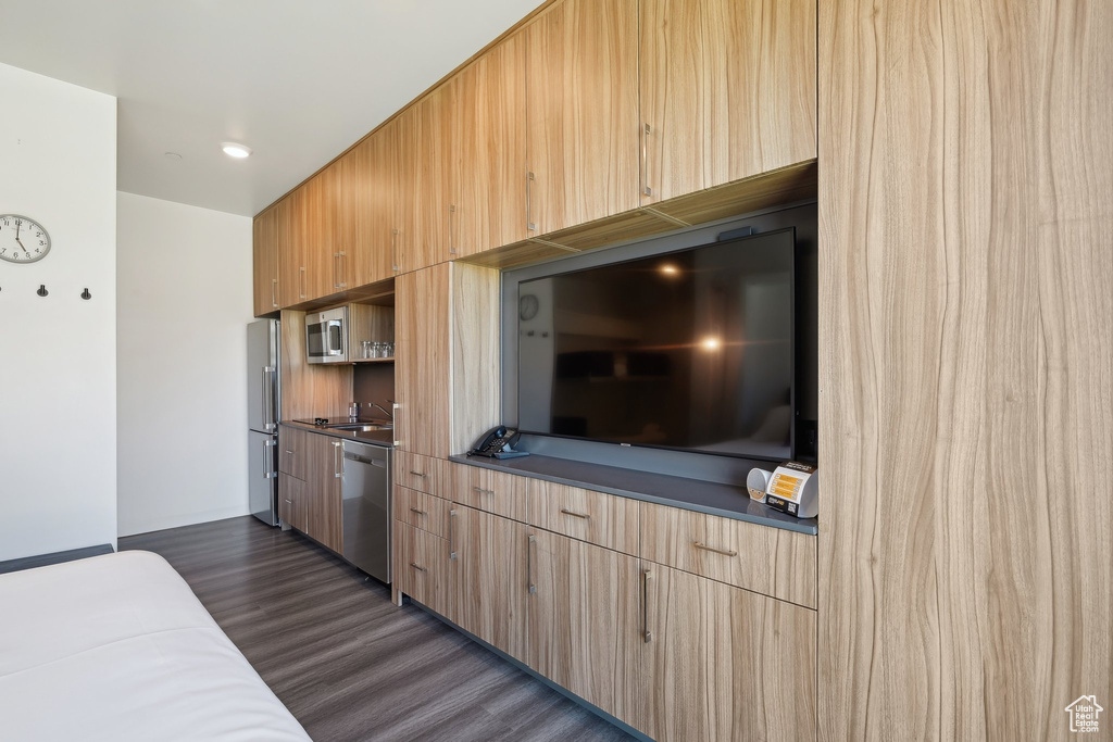 Kitchen with appliances with stainless steel finishes, dark wood finished floors, modern cabinets, and light brown cabinets