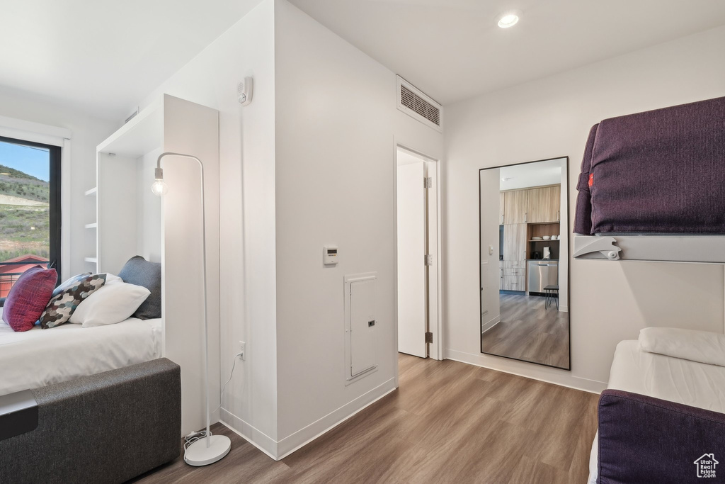 Corridor with wood finished floors, recessed lighting, and baseboards