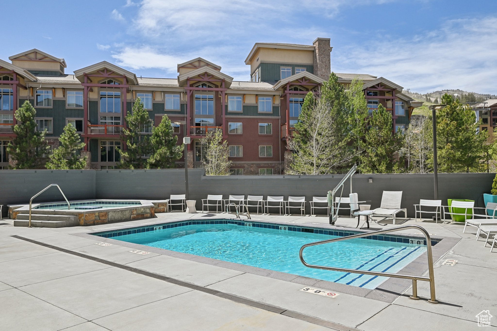 Community pool with a hot tub and a patio area