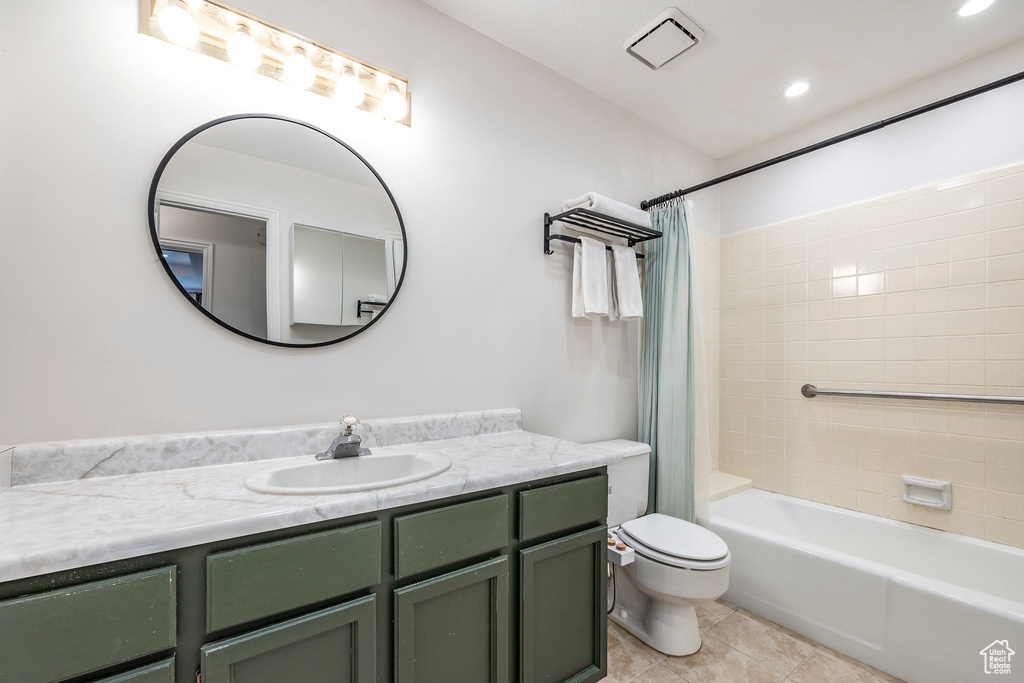 Bathroom with toilet, vanity, tile patterned flooring, shower / tub combo, and recessed lighting