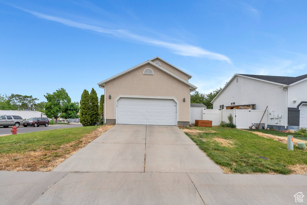 View of front of property with stucco siding, driveway, and an attached garage