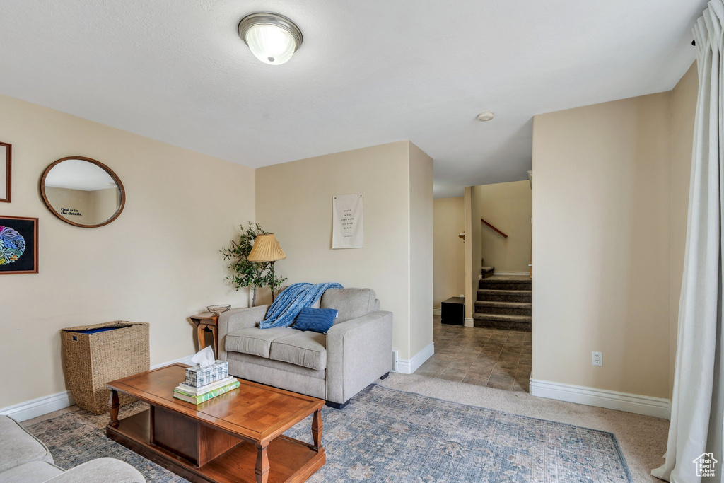 Carpeted living area with baseboards and stairs