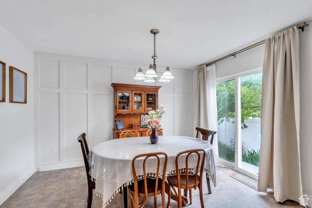 Dining area featuring a decorative wall and a chandelier