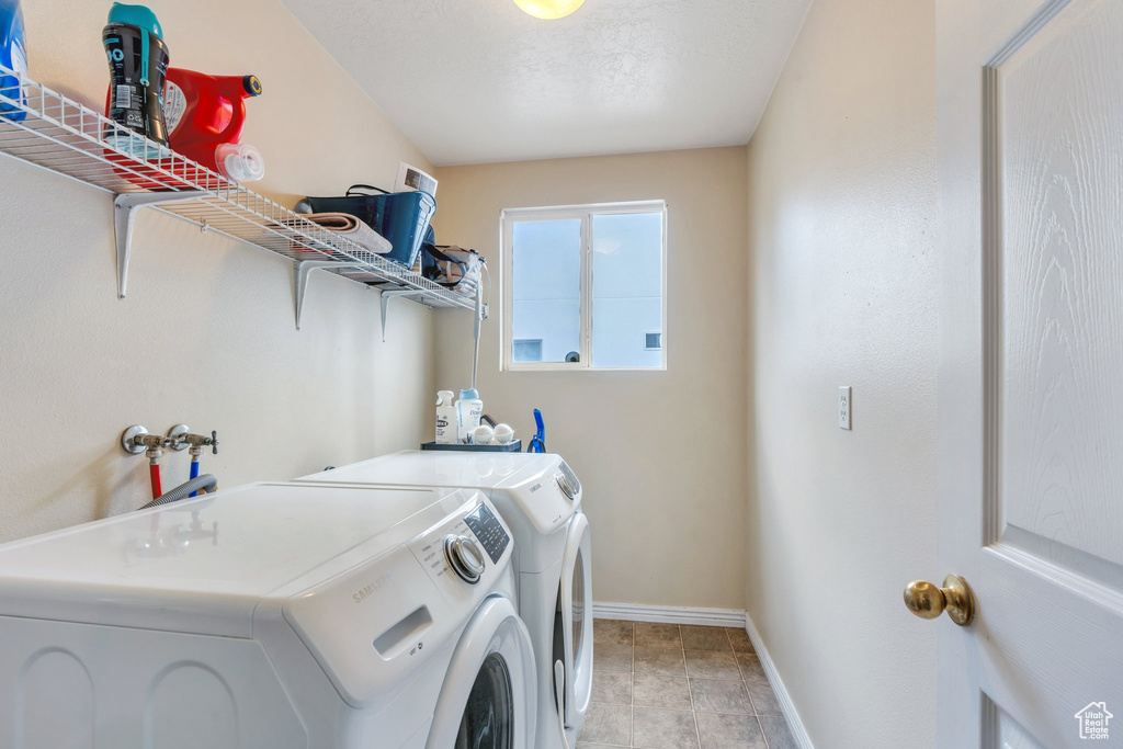 Washroom with washer and clothes dryer and baseboards