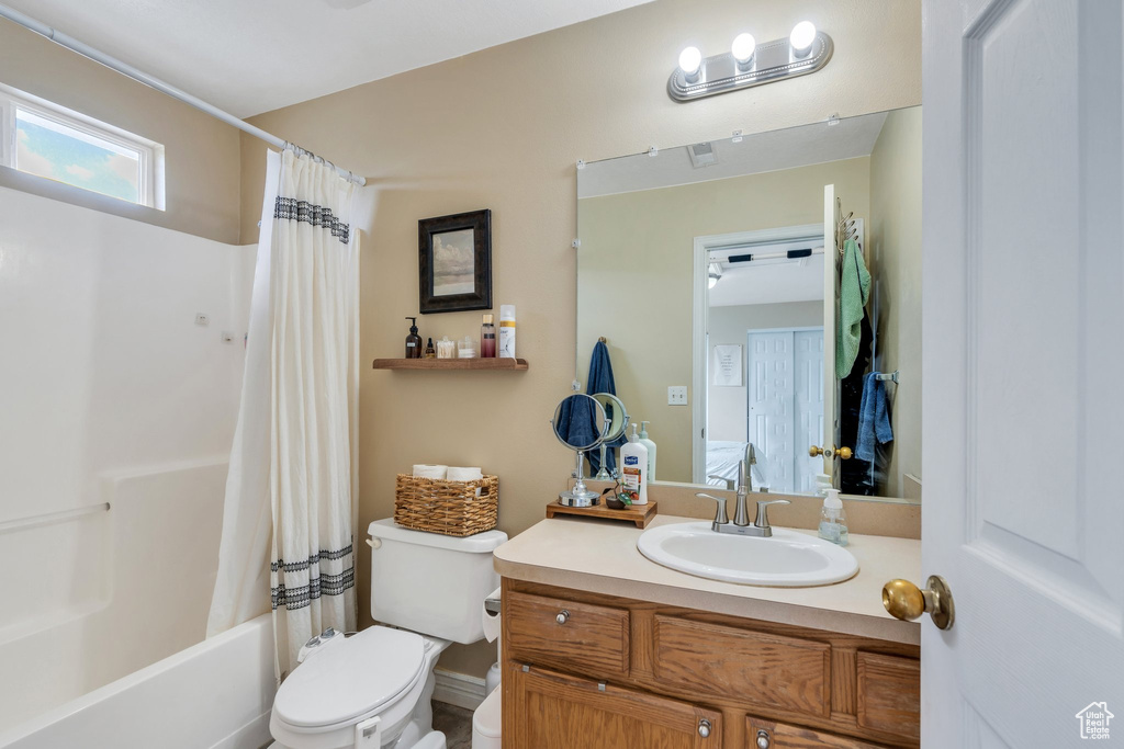 Full bath with toilet, vanity, and shower / bath combo