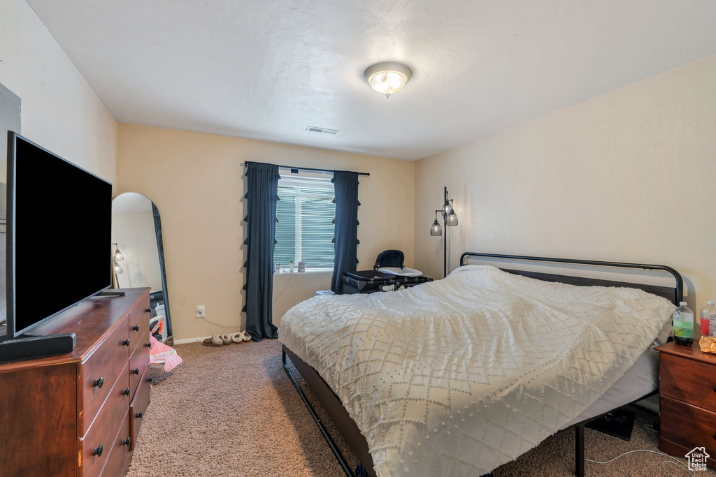 Carpeted bedroom with arched walkways and baseboards