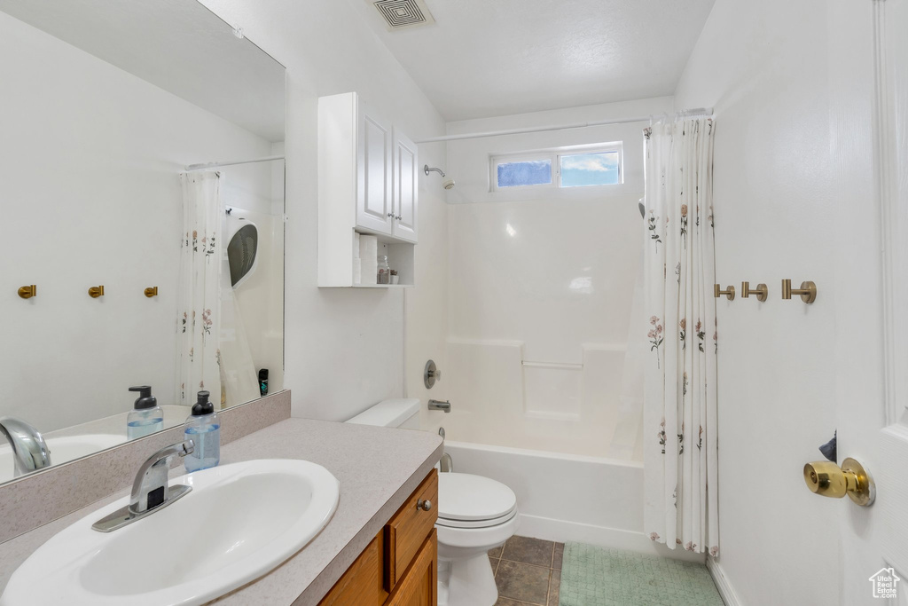 Bathroom with toilet, vanity, shower / tub combo, and tile patterned flooring