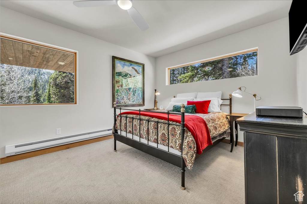 Bedroom with baseboard heating, ceiling fan, and baseboards