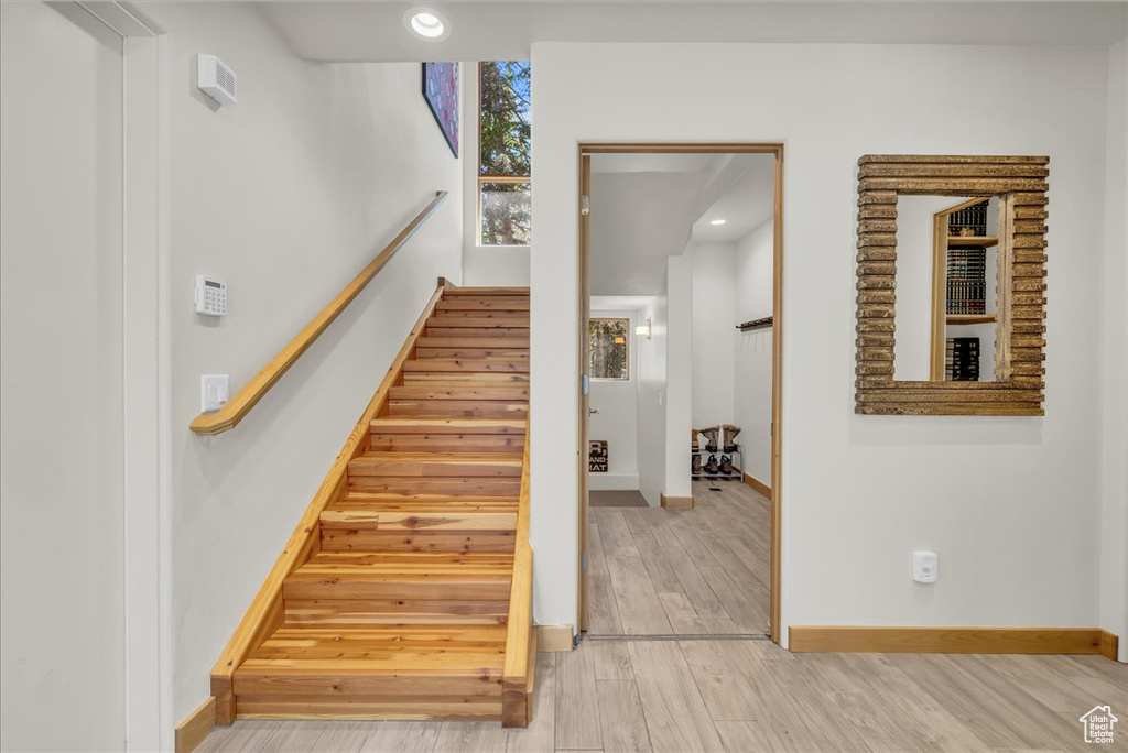 Staircase featuring baseboards, wood finished floors, and recessed lighting