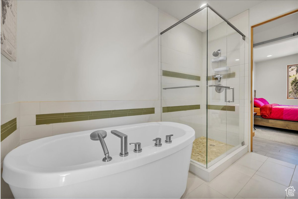 Full bath with a tub, a shower stall, tile patterned floors, and ensuite bathroom