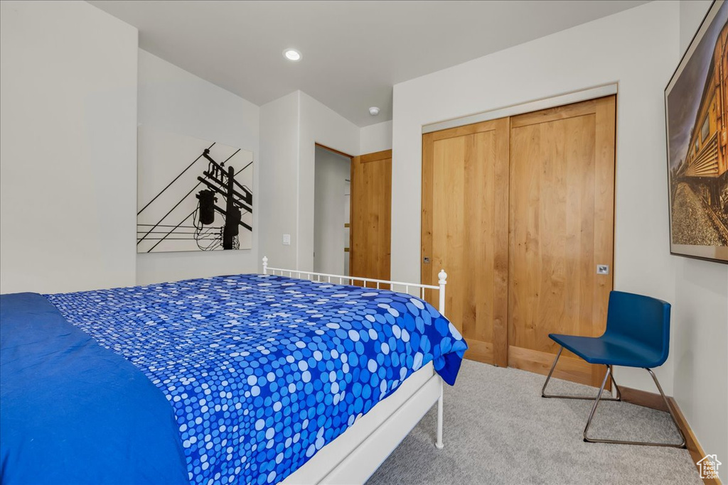 Carpeted bedroom with a closet and baseboards