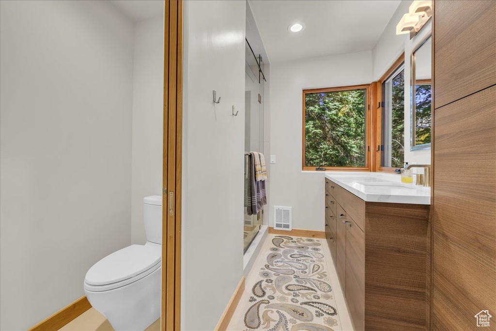 Bathroom with vanity, baseboards, toilet, and recessed lighting