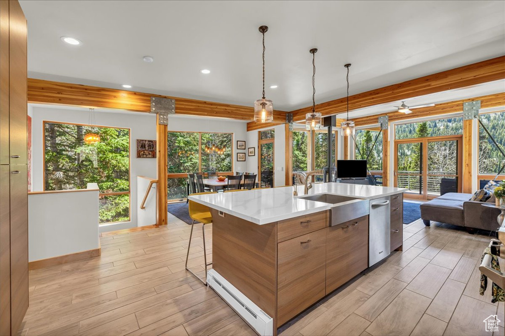 Kitchen with open floor plan, a sink, pendant lighting, light wood-style floors, and recessed lighting