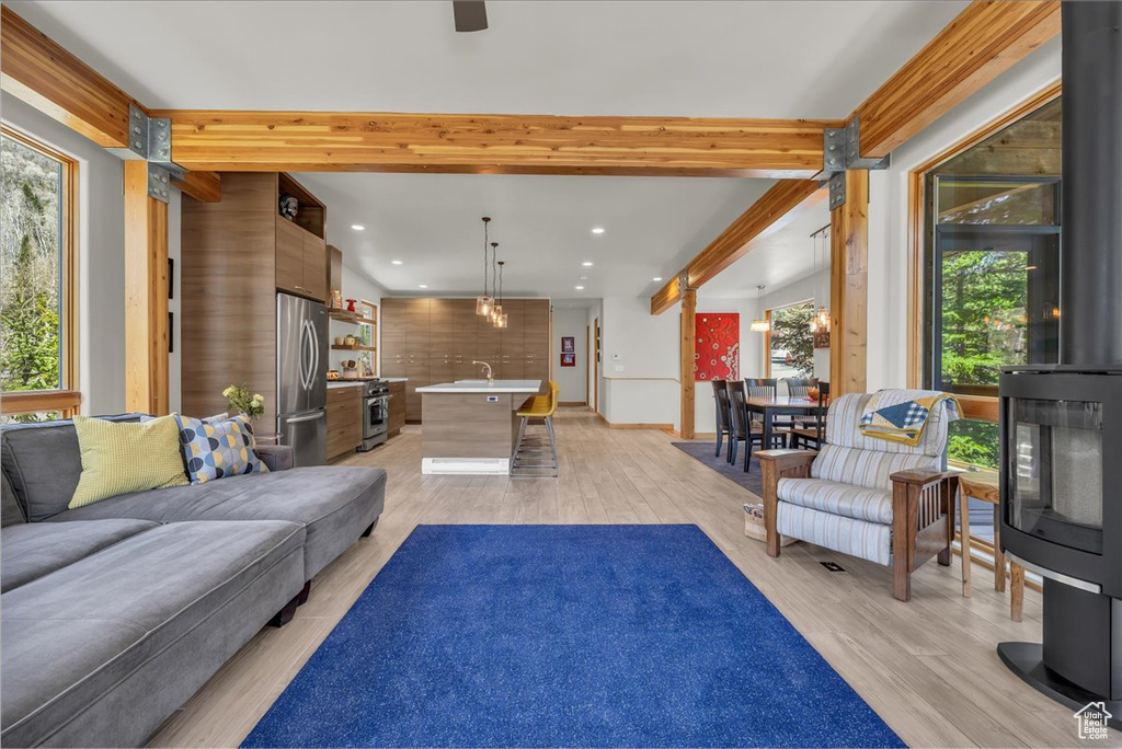 Living room featuring beam ceiling, recessed lighting, and light wood-style flooring