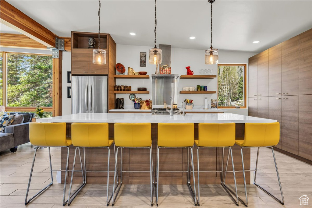 Kitchen featuring freestanding refrigerator, open shelves, light countertops, and recessed lighting