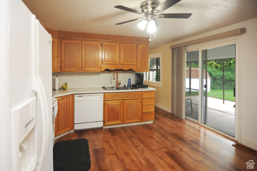 Kitchen featuring white appliances, a sink, light countertops, and ceiling fan