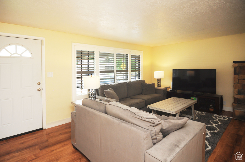 Living room featuring dark wood-style floors and baseboards