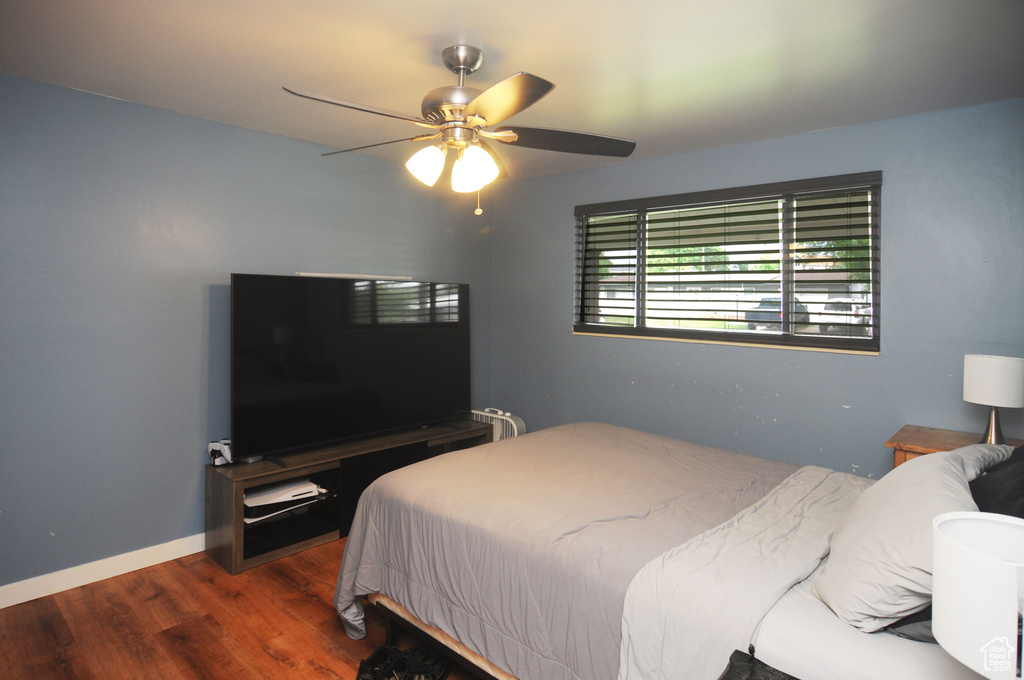 Bedroom featuring wood finished floors, a ceiling fan, and baseboards
