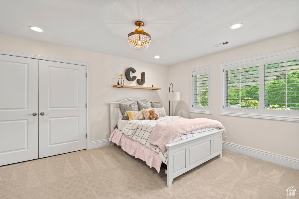 Bedroom featuring light carpet, baseboards, a chandelier, and recessed lighting