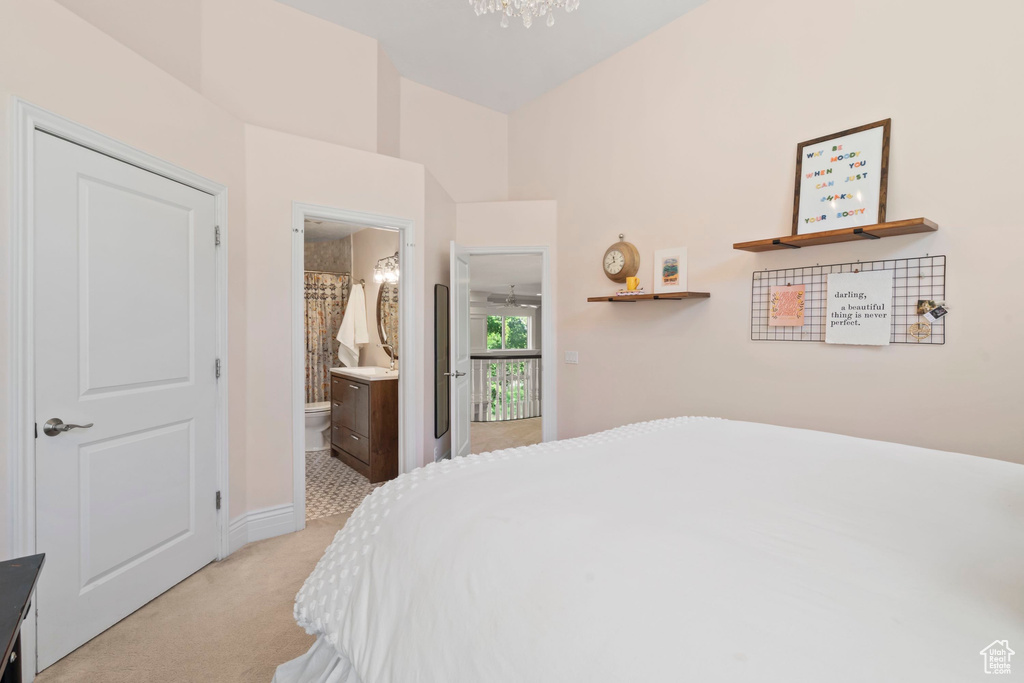 Bedroom featuring light colored carpet, a chandelier, and baseboards