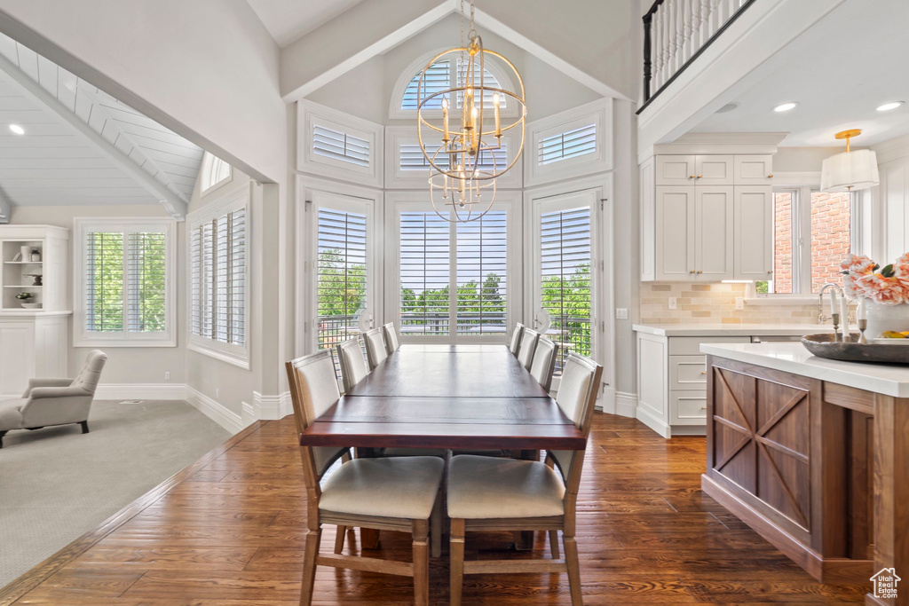Dining room featuring a chandelier, dark wood-style flooring, baseboards, high vaulted ceiling, and recessed lighting