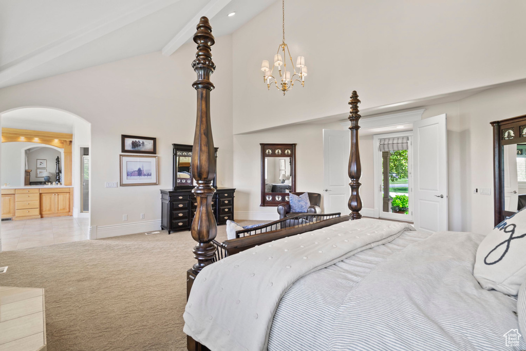Bedroom featuring arched walkways, baseboards, high vaulted ceiling, a chandelier, and light carpet