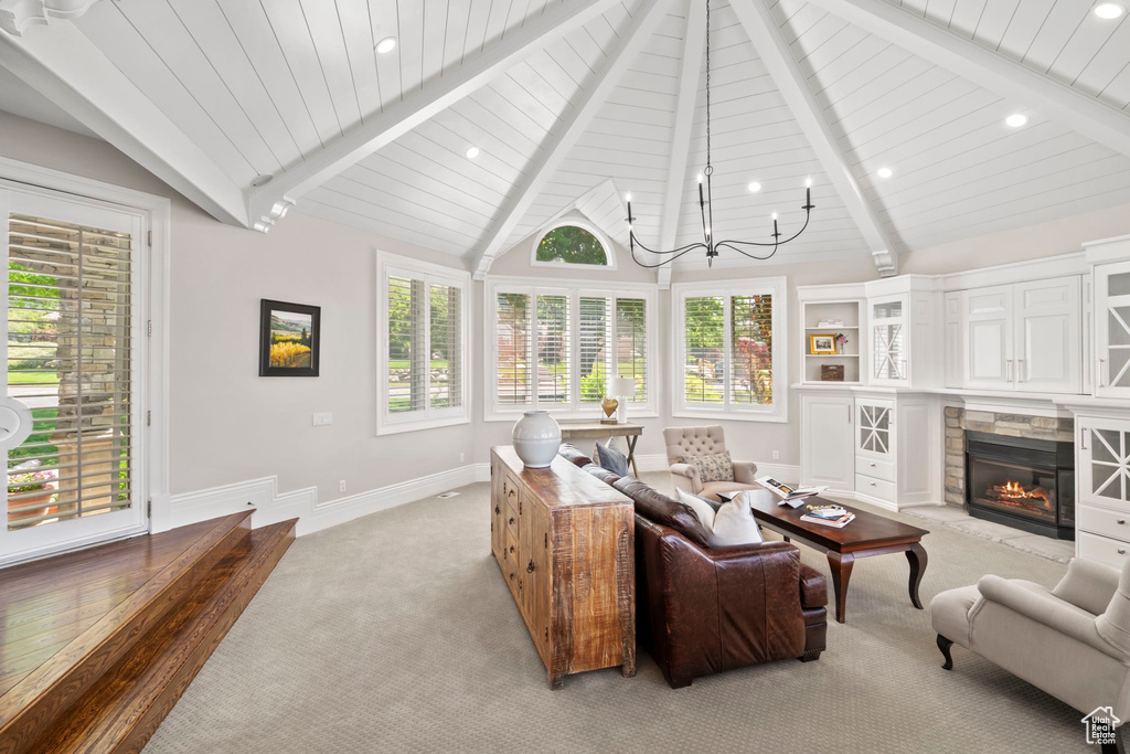 Living area with a glass covered fireplace, healthy amount of natural light, light colored carpet, recessed lighting, and baseboards