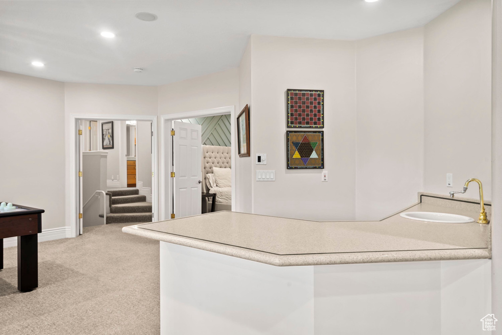 Kitchen with carpet floors, a sink, recessed lighting, light countertops, and baseboards