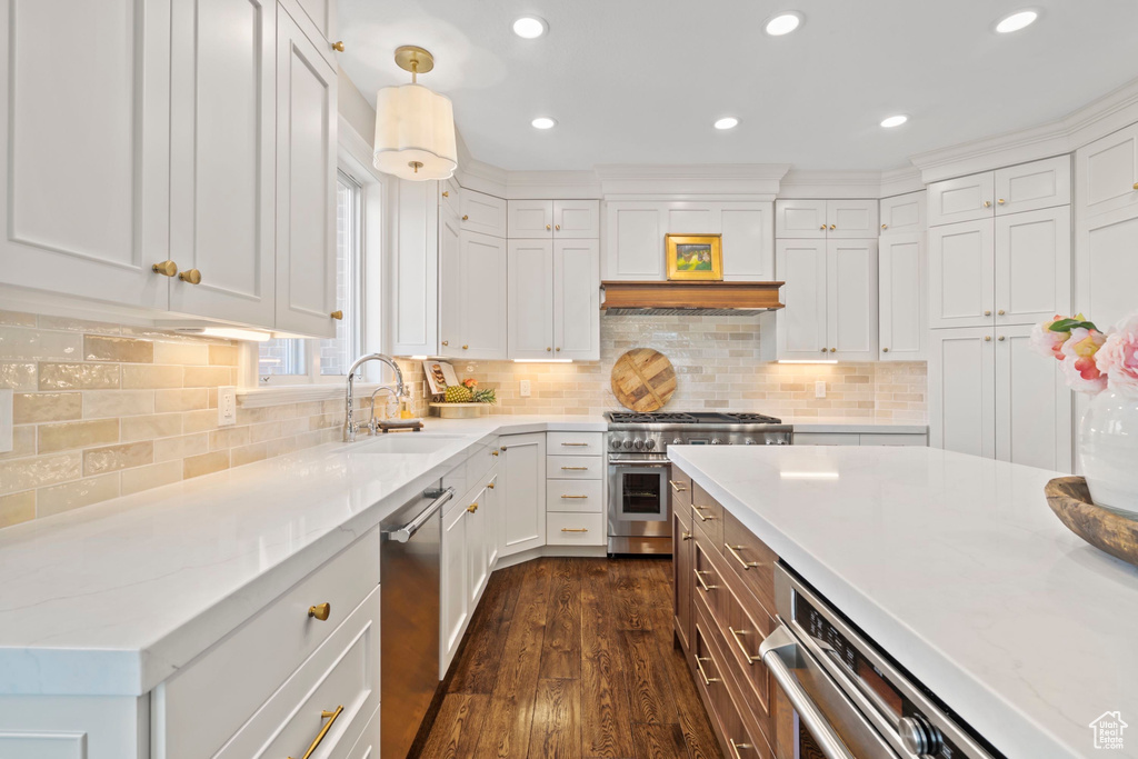 Kitchen featuring appliances with stainless steel finishes, a sink, dark wood-style flooring, white cabinets, and recessed lighting