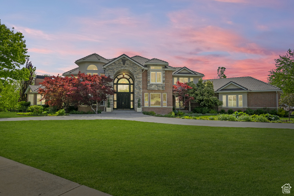 View of front of property with a front lawn, concrete driveway, and stucco siding