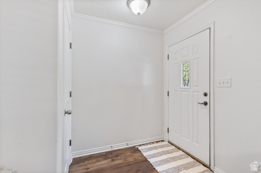 Foyer featuring crown molding and wood finished floors