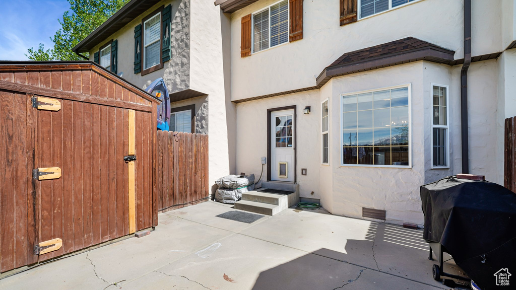 Back of property featuring stucco siding, fence, and a patio area