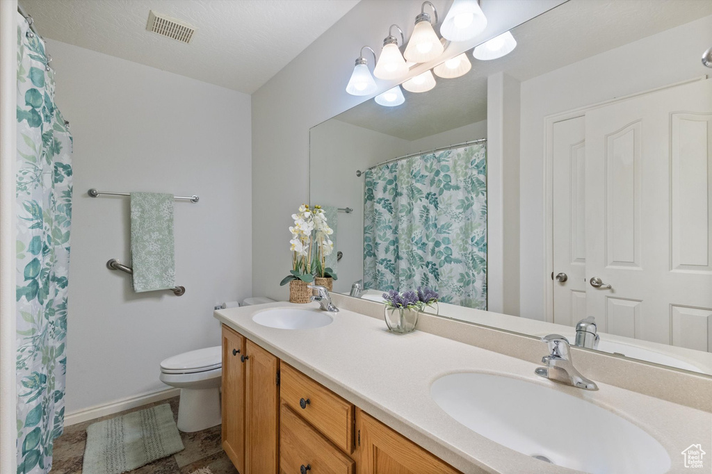 Bathroom with double vanity and curtained shower