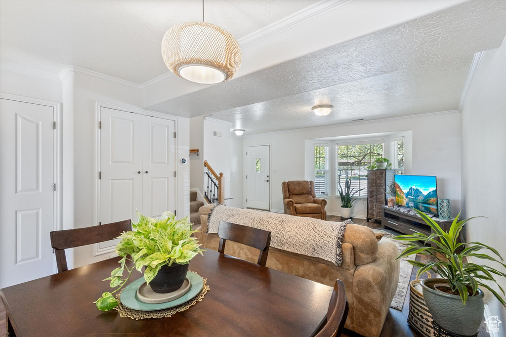 Dining room with stairs and ornamental molding