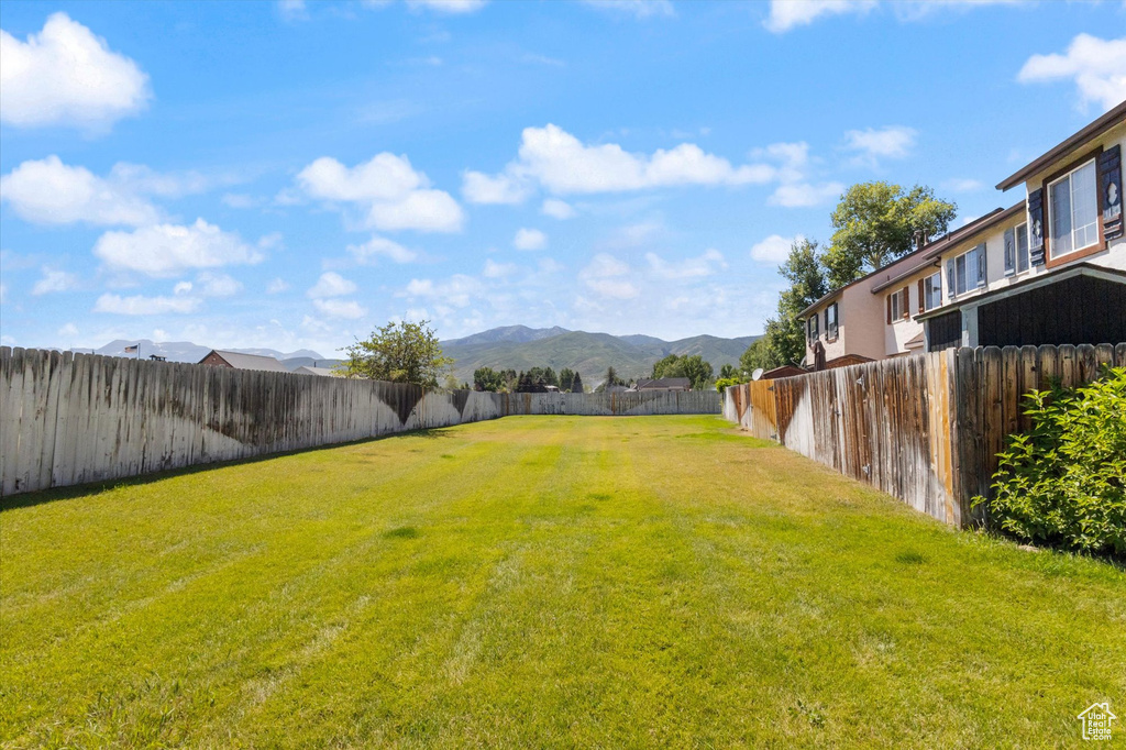 Fenced backyard featuring a mountain view