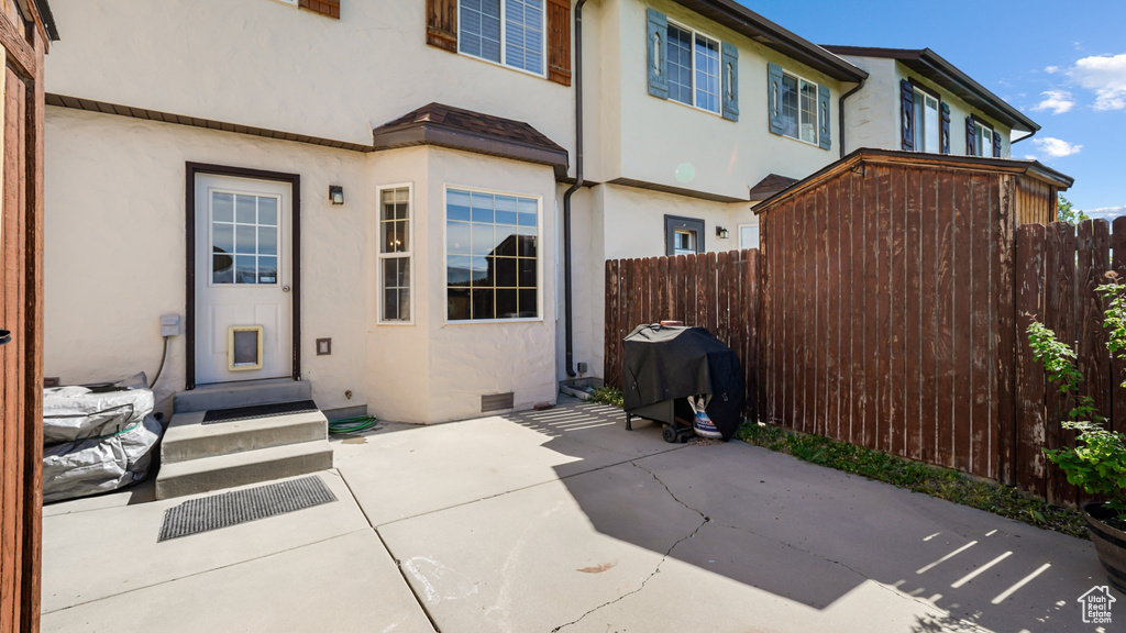 Back of property with stucco siding, fence, and a patio