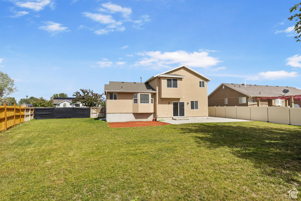Rear view of property featuring stucco siding and a patio area