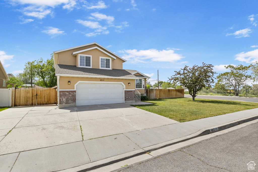 Traditional-style home with concrete driveway, stucco siding, a garage, and roof with shingles